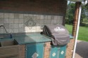 Grill area with concrete doors and countertop. Ceramic tile backsplash