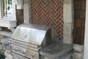 Brick backed fieldstone grill area with custom concrete countertops