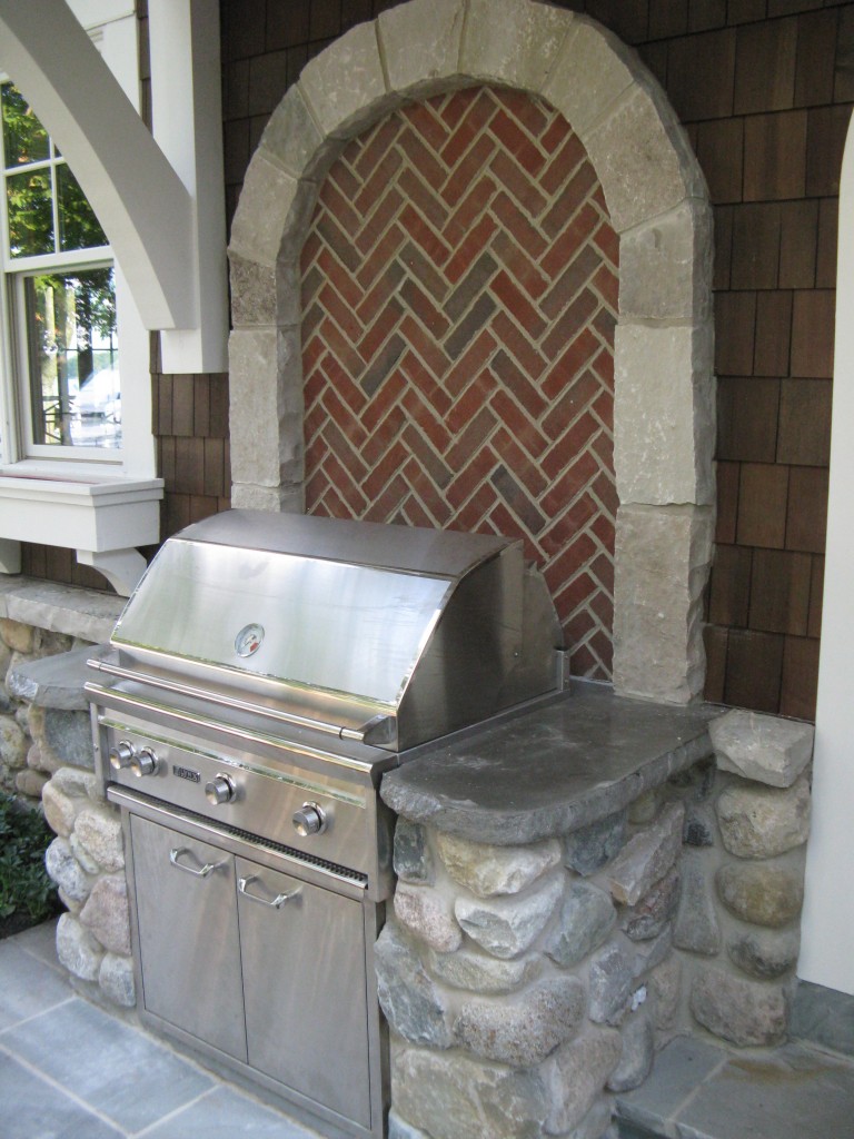 Brick backed fieldstone grill area with custom concrete countertops